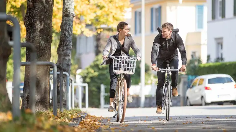 Zwei Radfahrer:innen fahren im Herbst zusammen Fahrrad Zwei Radfahrer:innen fahren im Herbst zusammen Fahrrad