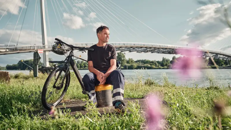 JobRadler Arbeitskleidung sitzt Wiese Brücke JobRadler Arbeitskleidung sitzt Wiese Brücke