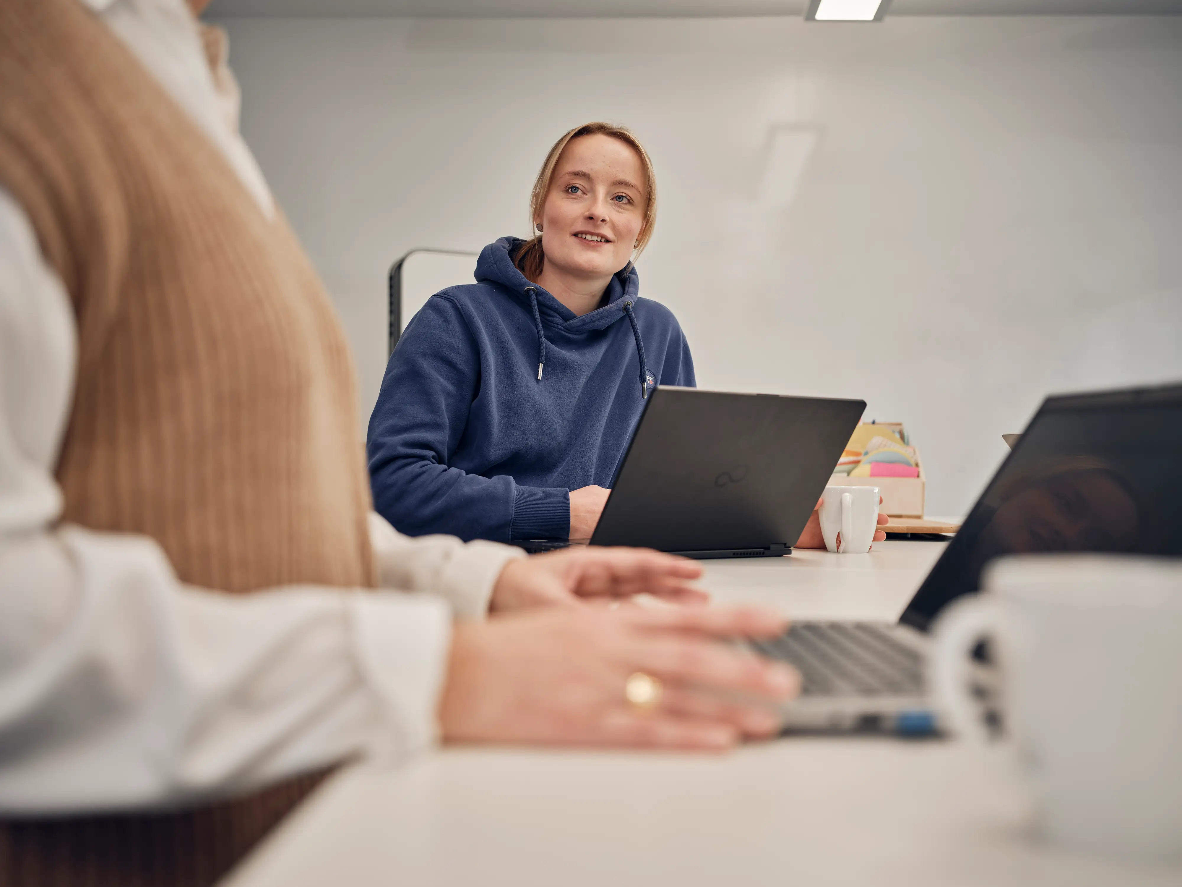 Blonde Frau blickt vom Laptop hoch Blonde Frau blickt vom Laptop hoch